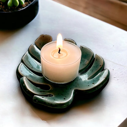 Blue Monstera leaf tealight holder with a lit candle life style image