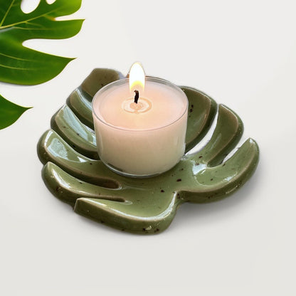 Green Monstera leaf tealight holder with a lit candle life style image