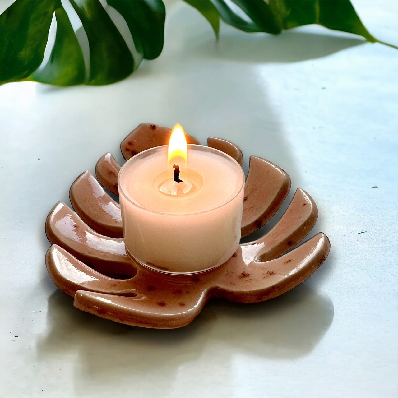 Pink Tealight Holder monstera leaf design with lit candle lifestyle image