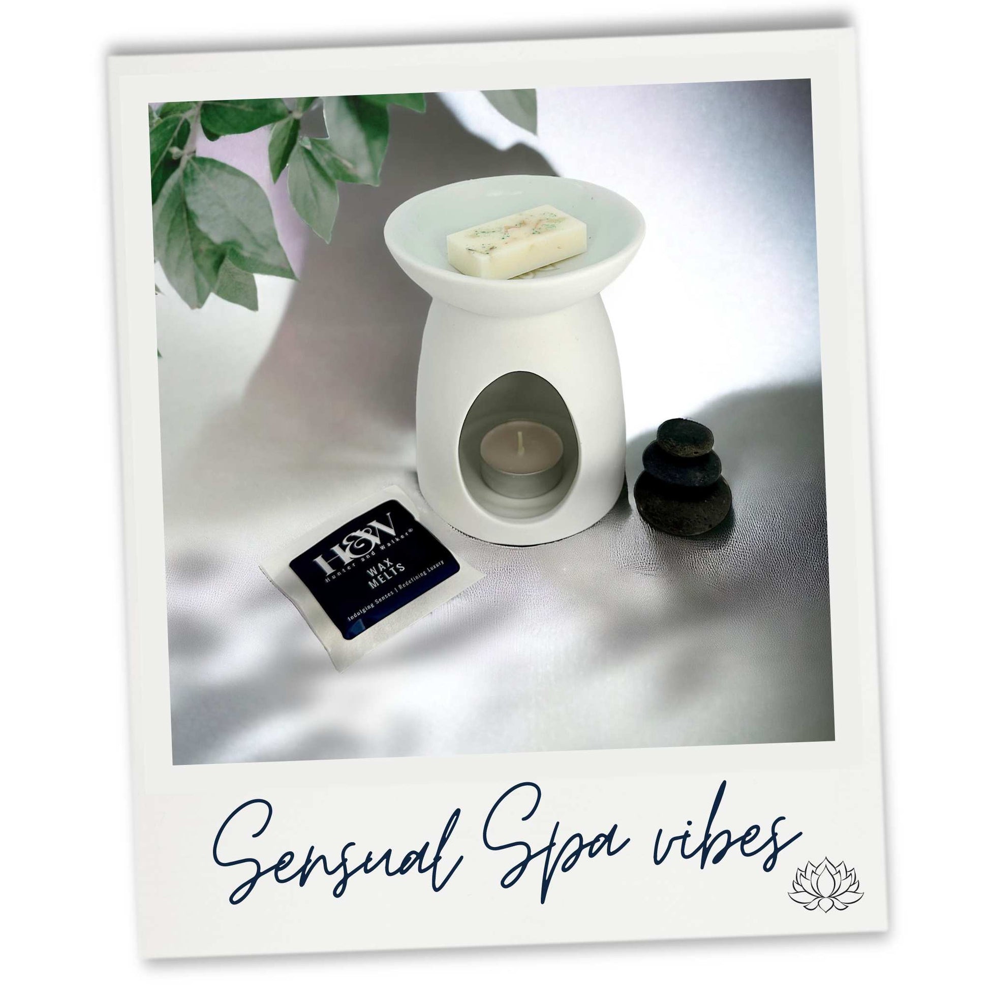 Sensual Spa wax melt sample image in a white mandala wax warmer next to a stack of three smooth dark pebbles